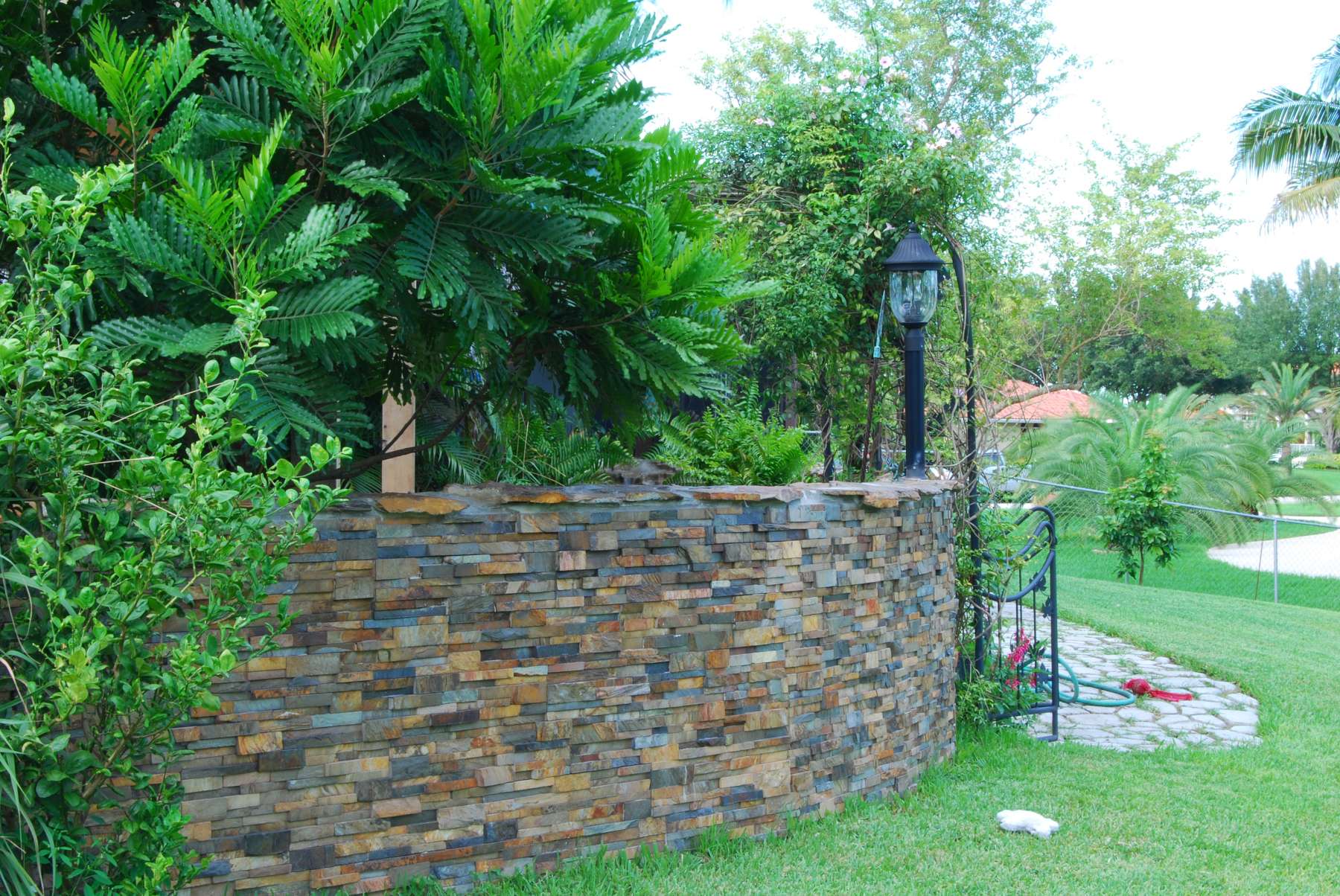 Curved Stacked Stone garden wall that has been sealed with an enhancing sealer